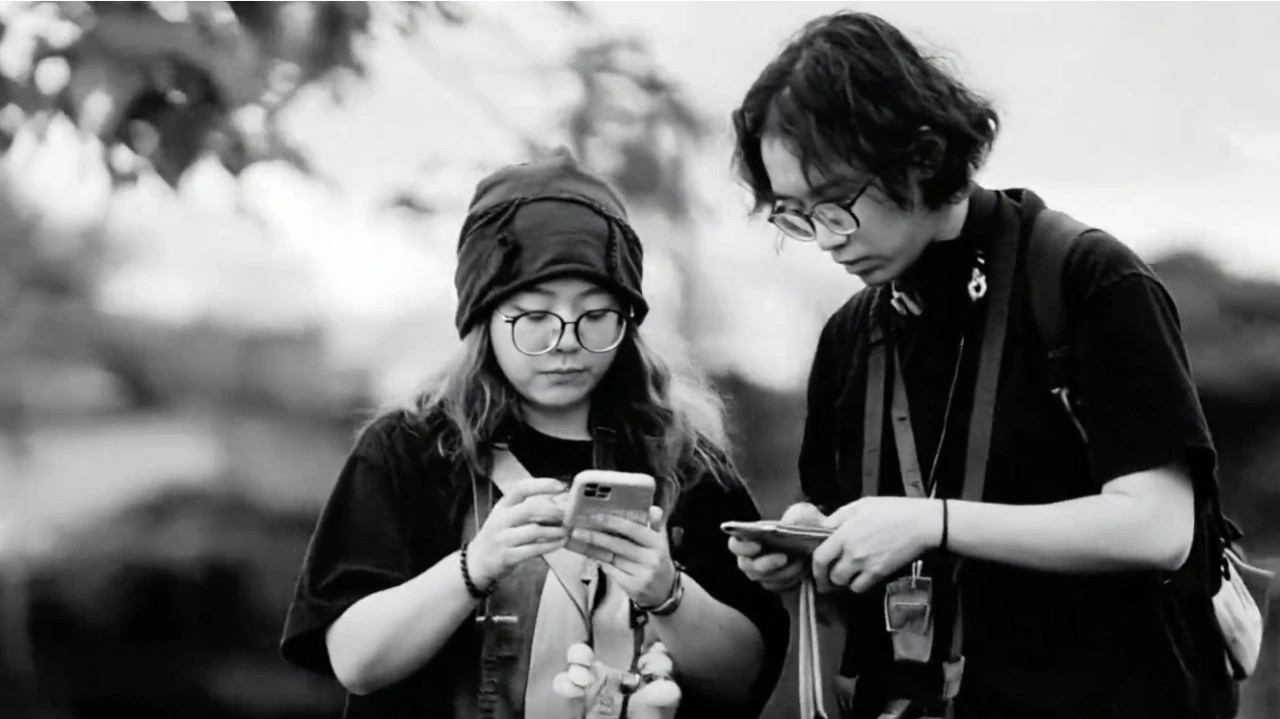 Two women in conversation outdoors in a black and white frame from Listening to the Tides